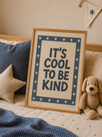 It's Cool to Be Kind statement poster styled on a cozy children's bed